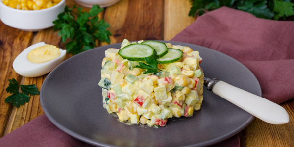 Салат із крабовими паличками, маринованими та свіжими огірками, кукурудзою й яйцями: простий рецепт